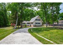 Charming two-story home featuring a well-maintained lawn, concrete driveway, and surrounded by mature trees at 1915 Redding Ln, Durham, NC 27712