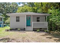 Charming single-story home with a welcoming front porch and a vibrant teal door at 2222 Oak Ridge Blvd, Durham, NC 27707