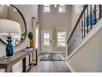 Bright foyer features a staircase, wood floors, a stylish mirror, and a console table with decor at 3004 Dog Rose Dr # 309, Durham, NC 27703