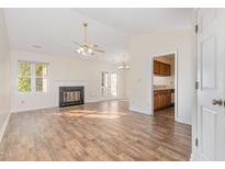 Inviting living room features a fireplace, ceiling fan and door leading to deck at 3325 Tarleton E, Durham, NC 27713