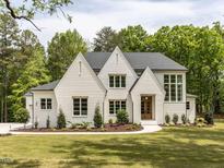 Stunning white brick home with manicured lawn, mature trees, and elegant design at 40 Ridgeline Ct # 10, Pittsboro, NC 27312