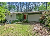 Charming single-story home featuring a red front door, minimalist landscaping and attached carport at 4501 Zebulon Rd, Zebulon, NC 27597