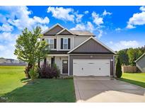 Charming two-story home featuring a well-manicured lawn and a two-car garage at 47 Peduncle St, Selma, NC 27576