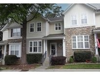 Charming townhome with stone and siding, a cozy front porch, and well-maintained landscaping at 5927 Hourglass Ct, Raleigh, NC 27612