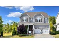 Charming two-story home with gray siding, a well-manicured lawn, and a two-car garage at 638 Boulder Point Dr, Chapel Hill, NC 27516