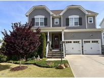 Charming two-story home with gray siding, stone accents, a well-manicured lawn, and a two-car garage at 638 Boulder Point Dr, Chapel Hill, NC 27516