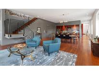 Open-concept living room featuring hardwood floors, exposed brick, and modern staircase design at 101 Morris St # D, Durham, NC 27701