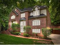 Stately two-story brick home featuring a landscaped front yard and a black shingle roof at 106 Birkhaven Dr, Cary, NC 27518