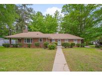 Charming brick home with a well-maintained lawn and mature trees providing shade at 1105 Hargrove St, Henderson, NC 27536