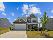 Two-story home featuring stone accents, neutral siding, and a two-car garage at 115 Bourne Dr, Franklinton, NC 27525