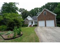 Charming brick and siding home with a well-manicured lawn and attached two-car garage at 1320 Taylor Farm Rd, Raleigh, NC 27603