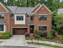 Charming brick home featuring a well-manicured lawn, two-car garage, and inviting entrance at 213 Old Franklin Grove Dr, Chapel Hill, NC 27514