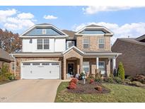 Charming two-story brick home with a well-manicured lawn, a two-car garage, and lovely front porch at 330 Macallan Dr, Burlington, NC 27215