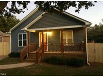 Charming home featuring blue siding, a cozy front porch with wood pillars and railings, and manicured landscaping at 405 Starrett Ct, Raleigh, NC 27603