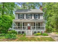 Charming two-story home with a welcoming front porch and mature landscaping at 4420 Tetbury Pl, Raleigh, NC 27613