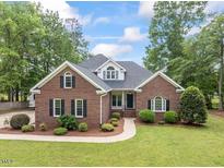 Charming brick home featuring mature landscaping, green lawn and neutral colors at 4612 River Farm Rd, Rocky Mount, NC 27803