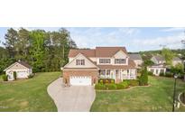 Charming two-story home boasts a manicured lawn, a brick-accented garage, and a welcoming front porch at 48 Falling Oak Ct, Clayton, NC 27520
