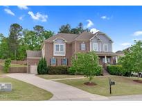 Charming two-story brick home with blue accents, lush landscaping, and a welcoming front yard at 5004 Clowser Minnow Ct, Wake Forest, NC 27587