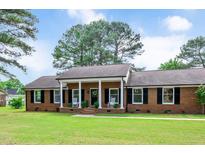 Charming red brick home with a covered front porch and well-manicured lawn, perfect for curb appeal at 603 Warren Rd, Erwin, NC 28339