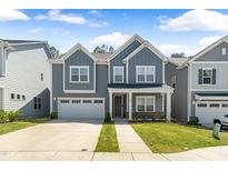 Charming two-story home with a well-manicured lawn and an attached two-car garage in a neighborhood setting at 608 Cormiche Ln, Wake Forest, NC 27587