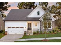 Charming two-story home with white siding, stone accents, a covered porch, and an attached two-car garage at Tbd Hudson Hills Rd, Pittsboro, NC 27312