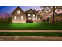 Stunning two-story brick home boasts a well-manicured lawn and elegant architectural details at 1004 Dunleigh Dr, Burlington, NC 27215
