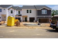 New construction homes showcase modern design with unfinished landscaping and two car garages at 1051 Winding Spring Dr, Mebane, NC 27302