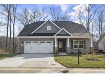 Charming single-story brick home featuring a two-car garage and a well-manicured front lawn at 1085 Fairhaven Dr # 49, Mebane, NC 27302