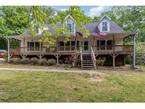 Charming two-story home with a covered porch and landscaped front yard surrounded by lush trees at 1176 Stoney Mountain Rd, Rougemont, NC 27572