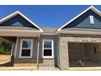New home construction showing gray siding, brick accents, and a two-car garage, reflecting modern design at 136 N Keatts Winner Ct, Clayton, NC 27520