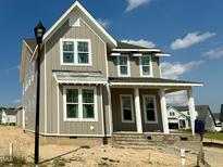 Charming two-story home featuring vertical siding, white trim and a welcoming front porch area at 1720 Bright Lantern Way, Wendell, NC 27591