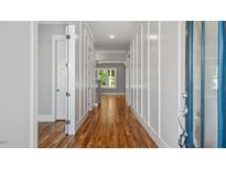 Inviting entryway with hardwood floors, white trim, and natural light streaming through the front door and into the home at 1733 Birdhaven Ln, Wendell, NC 27591