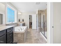 Beautiful primary bath featuring a soaking tub, tiled shower, and dual vanities at 2008 Campana Dr, Raleigh, NC 27603