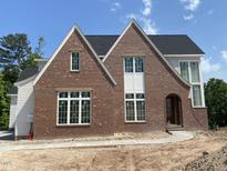 New two-story brick home featuring an arched front door and white trim windows at 2590 Silas Peak Ln, Apex, NC 27523