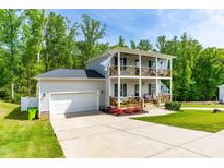 Charming two-story home featuring double balconies, a two-car garage, and a well-manicured lawn at 27 Ashley Woods Ct, Clayton, NC 27527