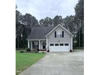 Charming home with a two-car garage, well-manicured lawn, and inviting front porch at 282 W Thicket Dr, Angier, NC 27501