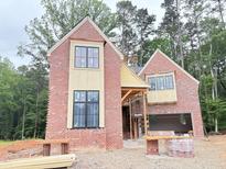 Two-story brick home with black-framed windows under construction with architectural details at 3324 Founding Place, Raleigh, NC 27612