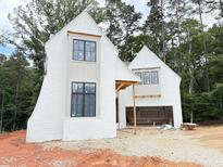 Two-story new construction home with a white painted brick exterior and large windows at 3324 Founding Place, Raleigh, NC 27612