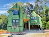 New home in construction phase, showcasing framing, black windows, and green weather resistant barrier at 3324 Founding Place, Raleigh, NC 27612