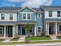 Charming new townhome with blue siding, stone accents, landscaped yard, and inviting front entrance at 3712 Rosebush Dr, Zebulon, NC 27597