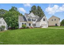 Charming two-story white home featuring a well-manicured lawn and mature trees at 4418 Gallatree Ln, Raleigh, NC 27616
