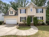 Charming two-story home features a well-manicured lawn, attached garage, and beautiful landscaping at 517 Hidden Cellars Dr, Holly Springs, NC 27540