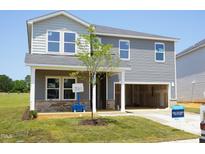 Charming two-story home featuring an attached two-car garage and newly installed green lawn at 677 White Birch Ln, Angier, NC 27501