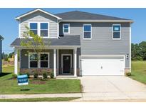 Charming two-story home with gray siding, a two-car garage, and a well-manicured front yard at 677 White Birch Ln, Angier, NC 27501