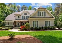 Beautiful two-story home featuring a well-manicured lawn, complemented by lush landscaping and a welcoming entryway at 7400 Portpatrick Ct, Wake Forest, NC 27587