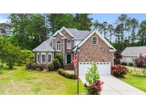 Charming brick two-story home featuring an attached two-car garage and beautifully landscaped front yard at 7405 Pine Summit Dr, Fuquay Varina, NC 27526