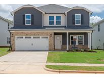 Two-story home with a two car garage, gray siding, brick facade, and well manicured front yard at 741 Deschutes Dr, Garner, NC 27529