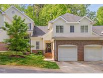 Inviting home featuring brick accents, a well-manicured lawn, and an attached two car garage at 7705 Astoria Pl, Raleigh, NC 27612