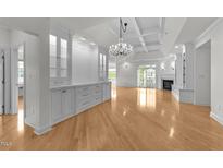 Bright and airy living room features hardwood floors, custom built-ins, and a crystal chandelier at 10410 Rosegate Ct # 307, Raleigh, NC 27617