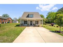 Charming home featuring a well-manicured lawn and long driveway at 109 E Fayetteville St, Micro, NC 27555